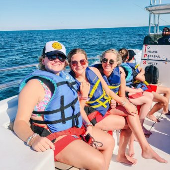 a group of people sitting in a boat on a body of water