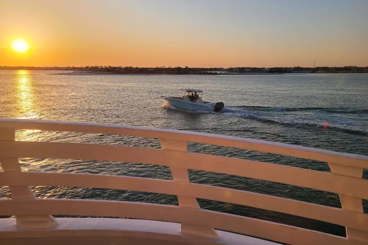 a boat in a body of water at sunset