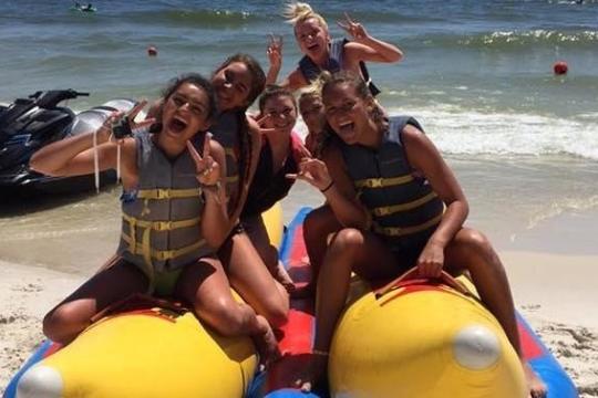 a group of people sitting on a banana boat on the beach