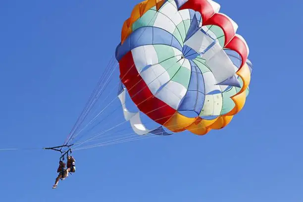 two people parasailing in the air