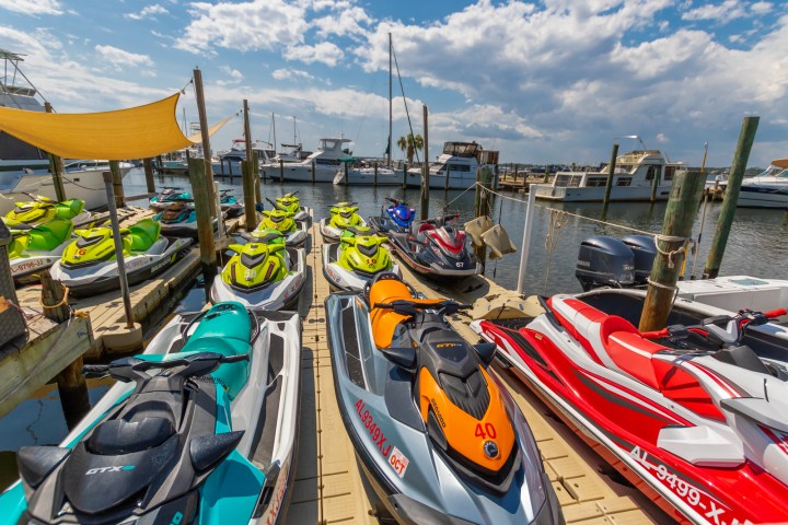 a row of parked jetskis sitting on top of a dock