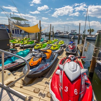 a row of parked jetskis sitting on top of a dock