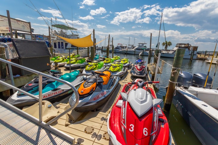 a row of parked jetskis sitting on top of a dock