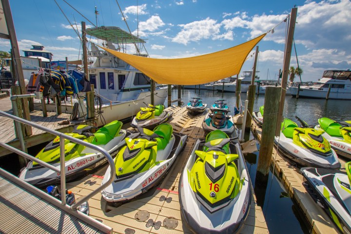 a row of parked jetskis sitting on top of a dock