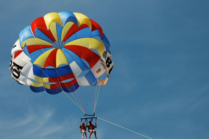 two people parasailing in the sky