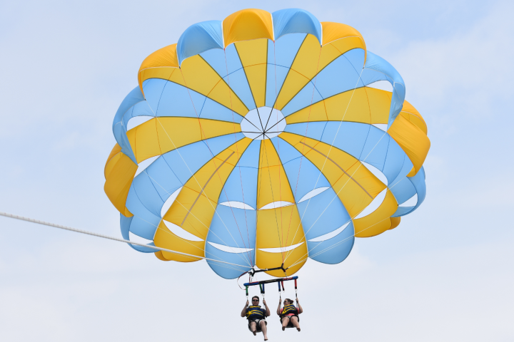 two people parasailing in the sky