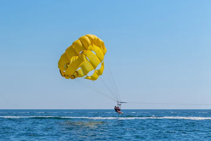 a group of people parasailing above a body of water